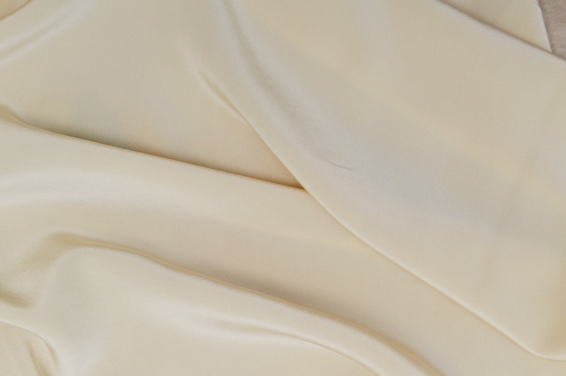 A neutral-toned bra folded on linen.