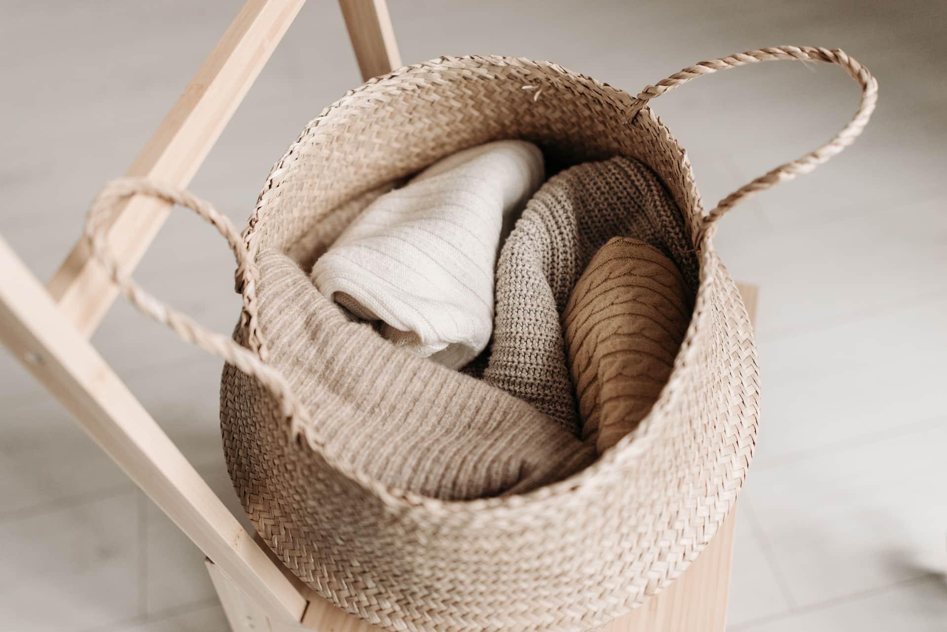 Neutral-toned trousers folded over the back of a chair.