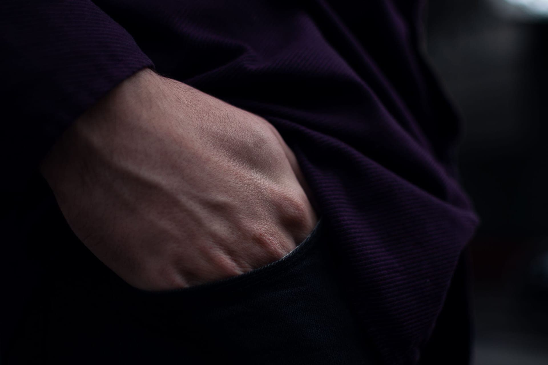 A hand slipping into the side pocket of a pair of leggings.