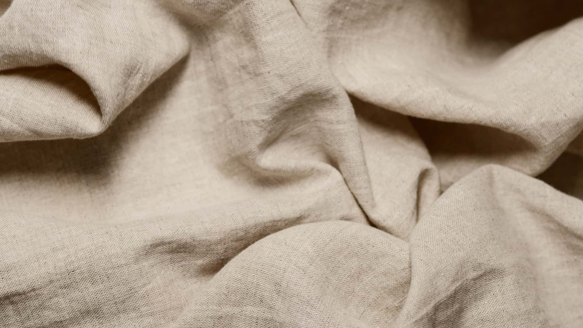 Folded cotton underwear on neutral linen.