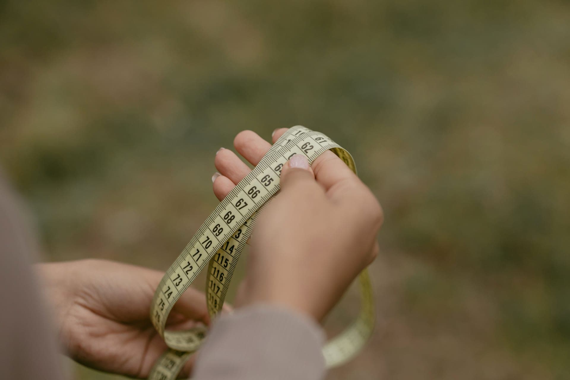 A measuring tape resting on neutral fabric.