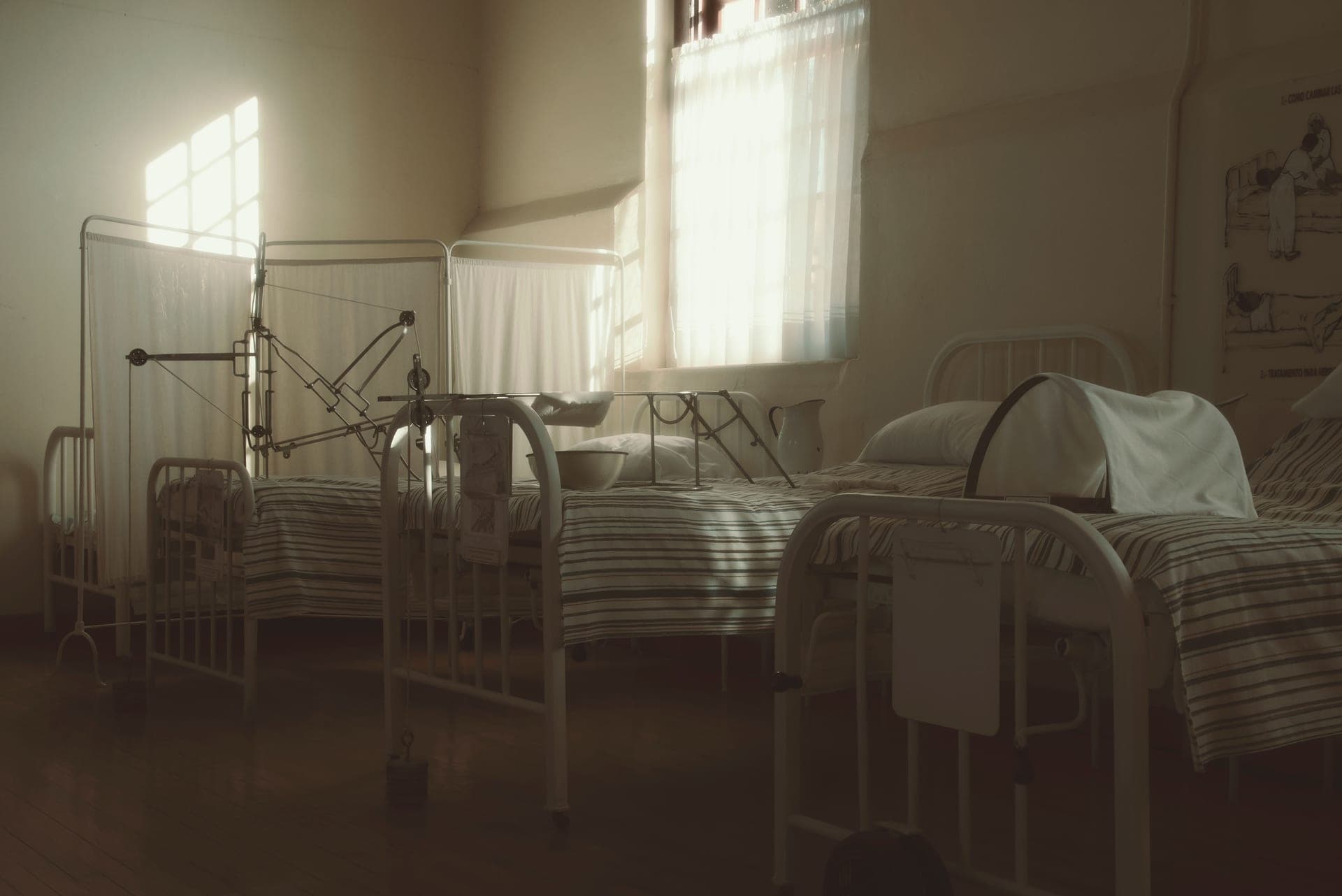 A calm, neutral hospital room with a made bed.