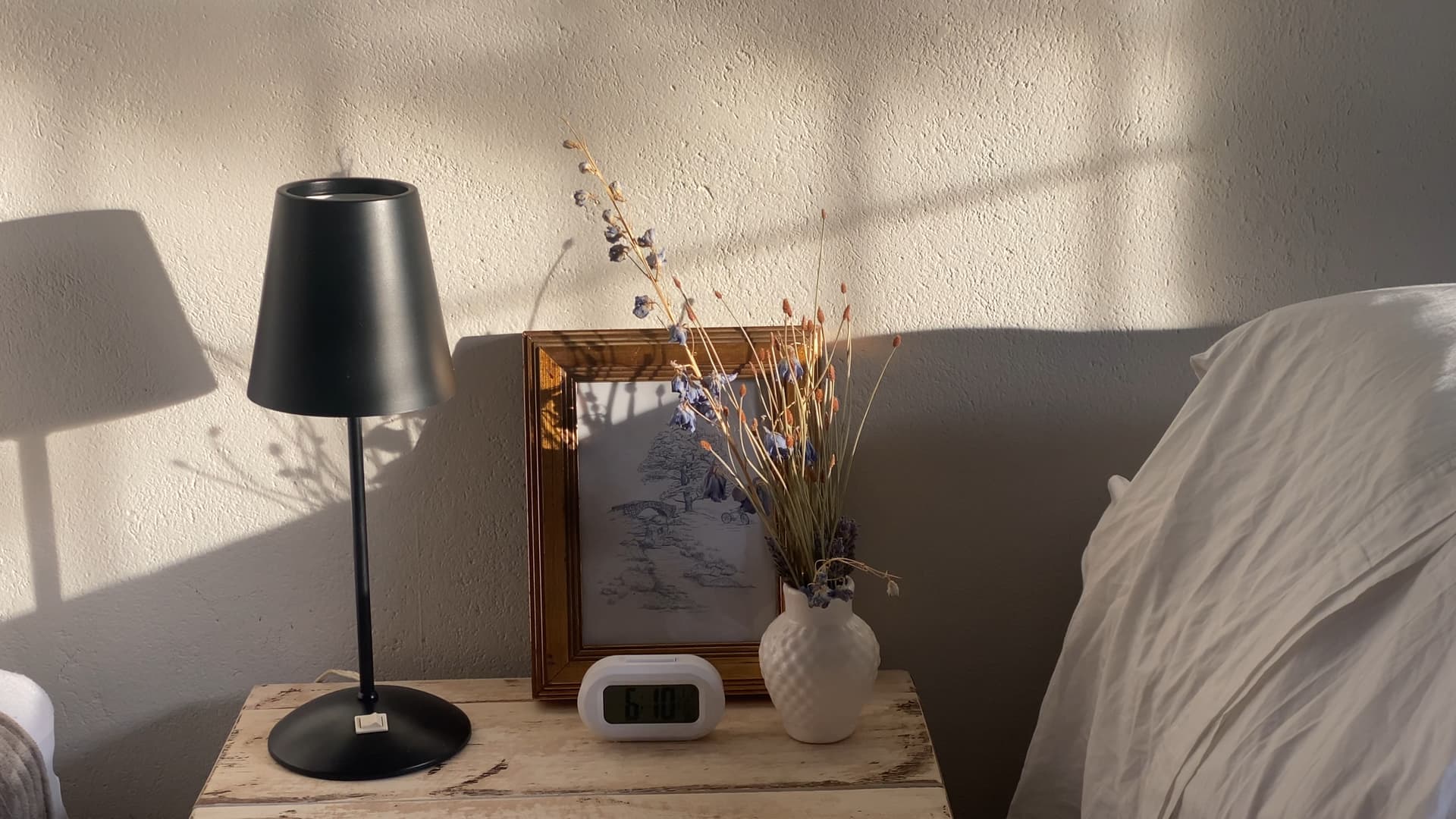 A calm bedroom interior with a lamp and a vase.