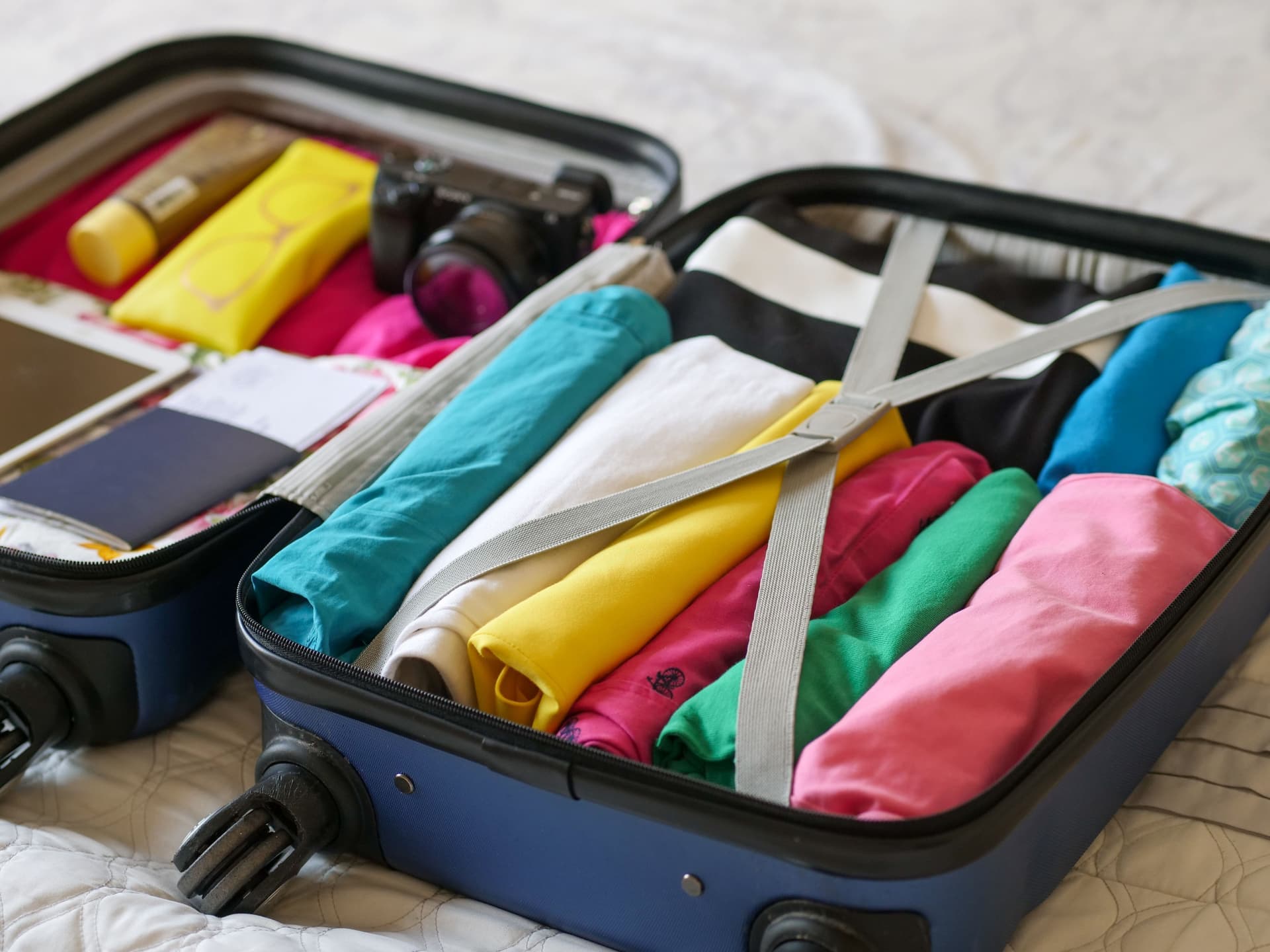 A suitcase packed with neatly folded clothes.